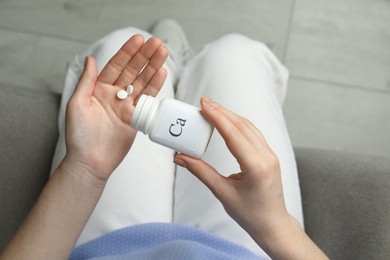 Photo of Calcium supplement. Woman taking pills indoors, top view