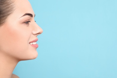 Photo of Portrait of young woman with beautiful face and natural makeup on color background, closeup. Space for text