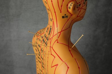 Photo of Acupuncture - alternative medicine. Human model with needles in shoulder against dark grey background