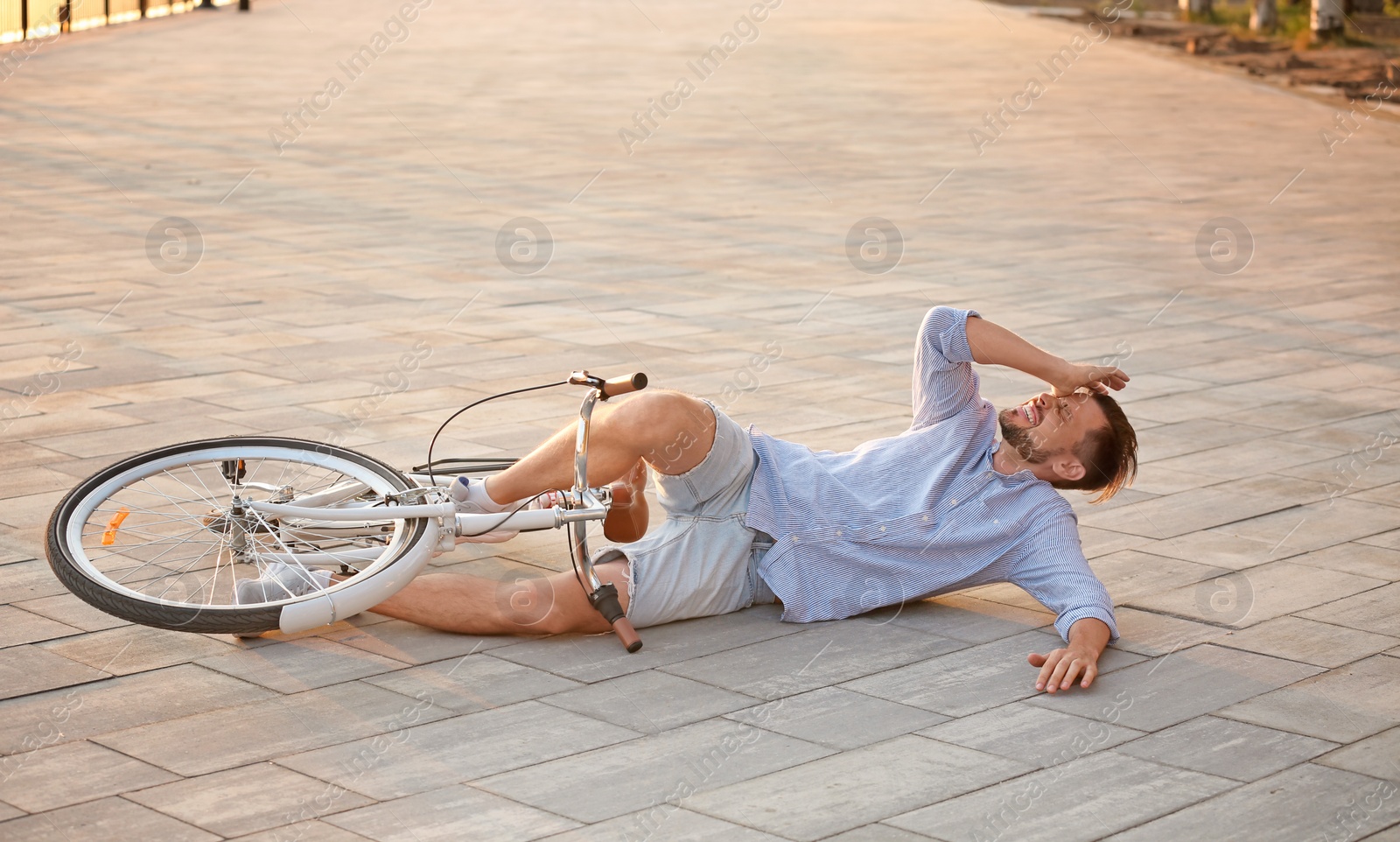 Photo of Man fallen off his bicycle on street