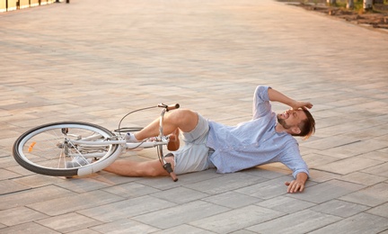 Man fallen off his bicycle on street