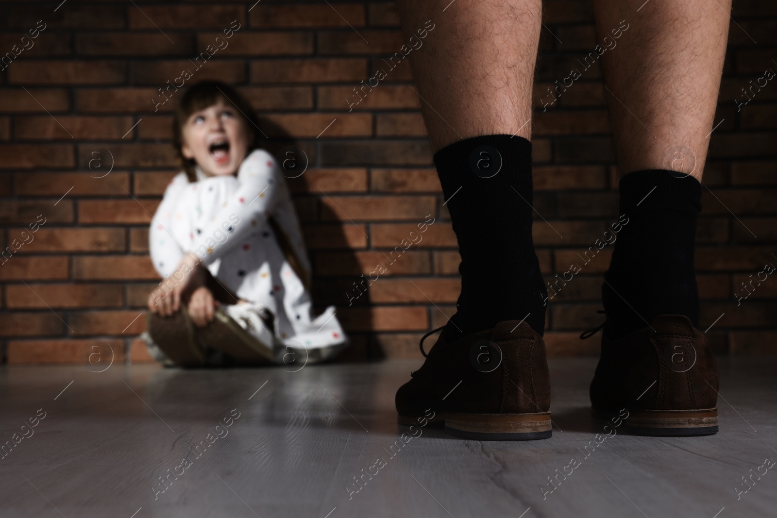 Photo of Adult man without pants standing in front of scared little girl indoors. Child in danger