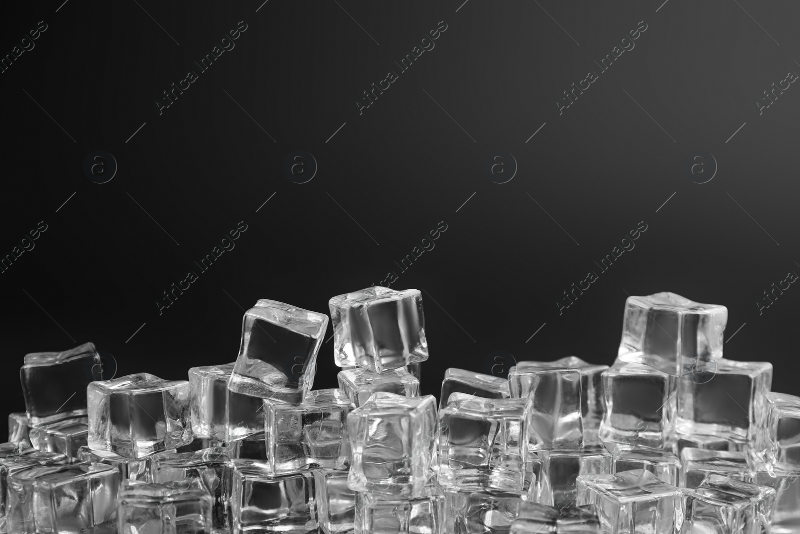 Photo of Crystal clear ice cubes on black background. Space for text