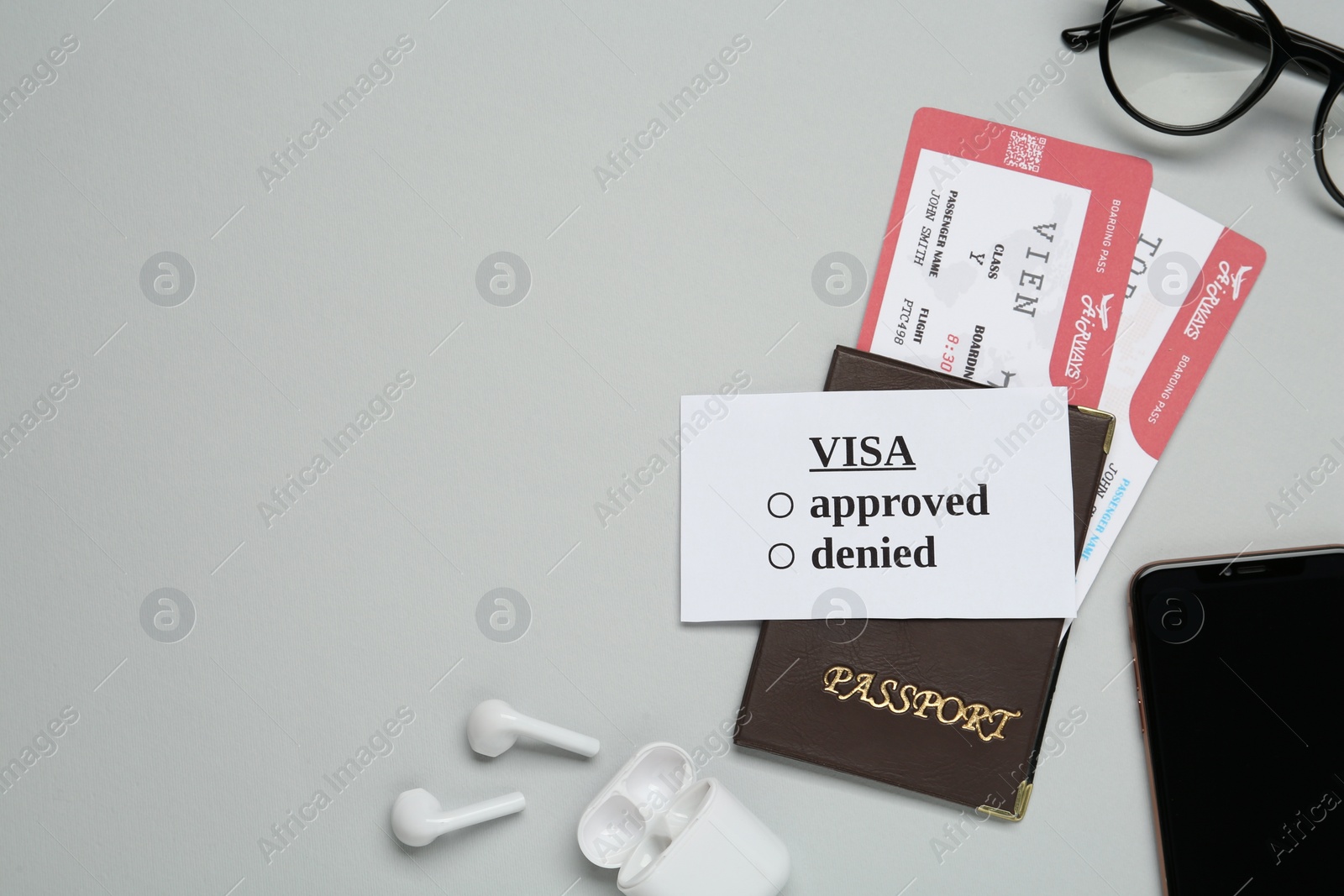 Photo of Flat lay composition with passport, tickets and earphones on light grey background, space for text. Visa receiving