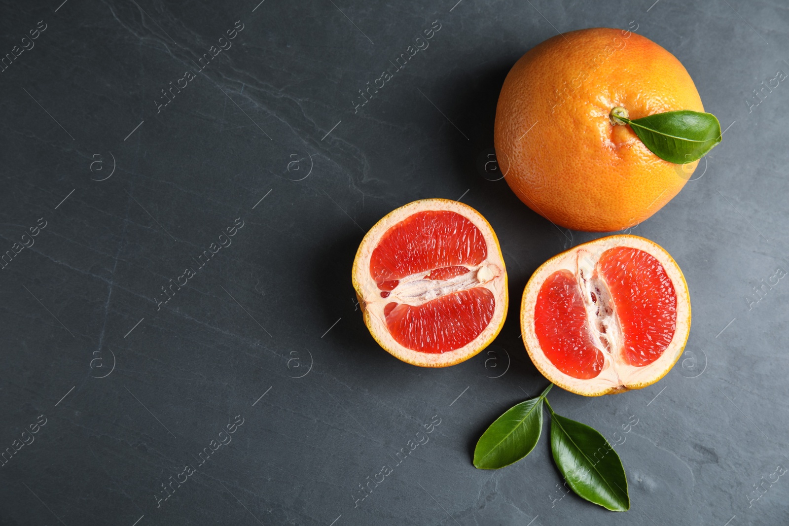 Photo of Fresh tasty grapefruits on table, top view with space for text