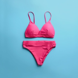 Photo of Beautiful pink bikini on light blue background, top view