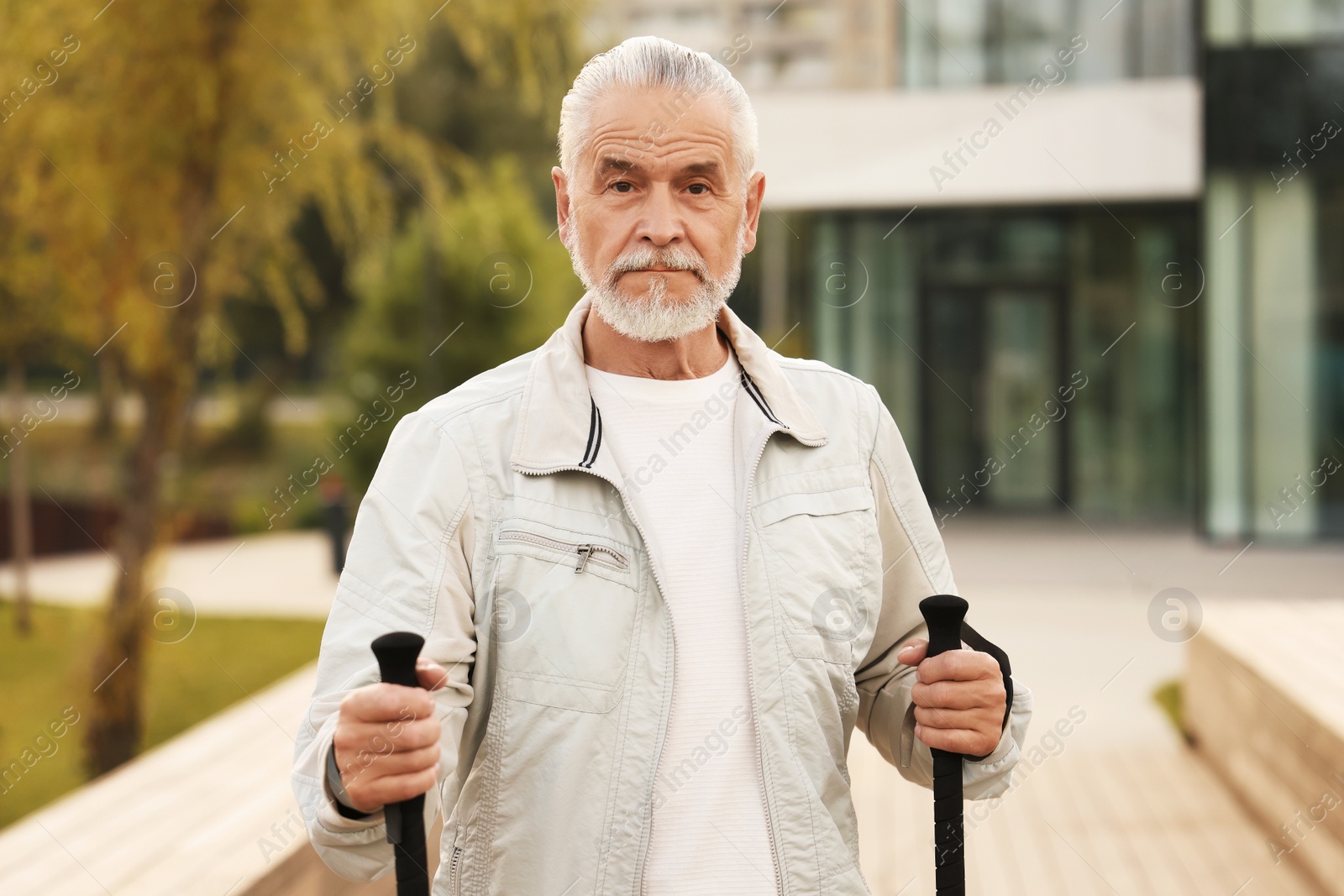 Photo of Senior man with Nordic walking poles outdoors