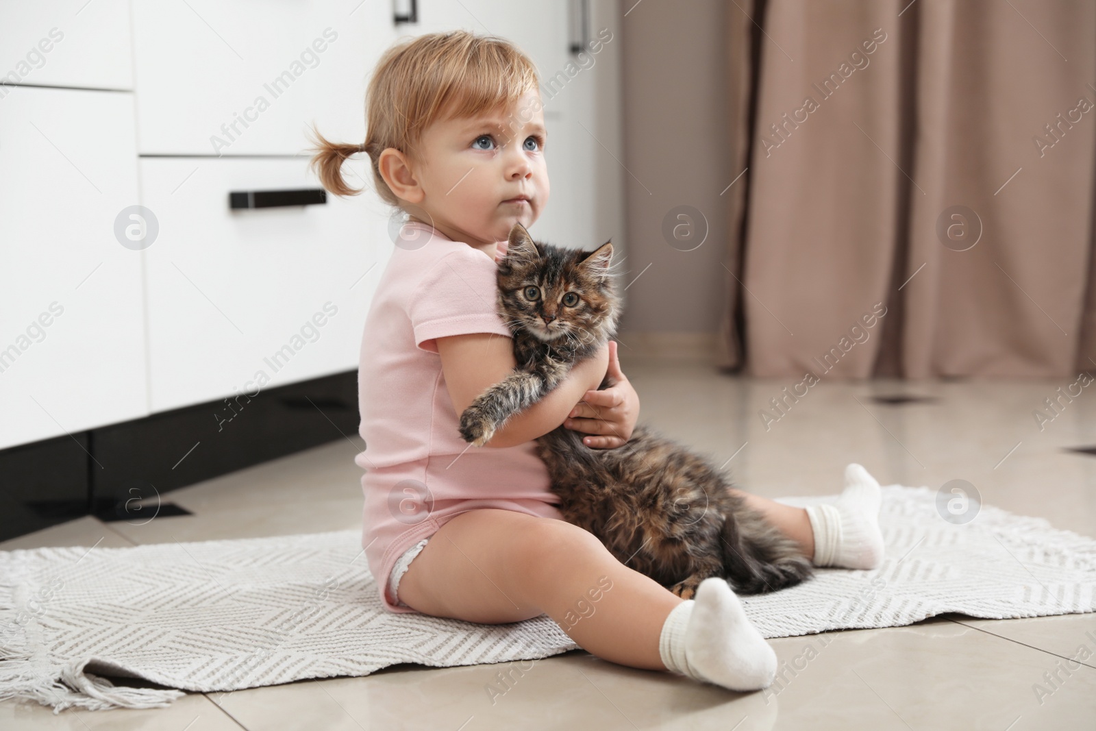 Photo of Cute little child with adorable pet on floor at home