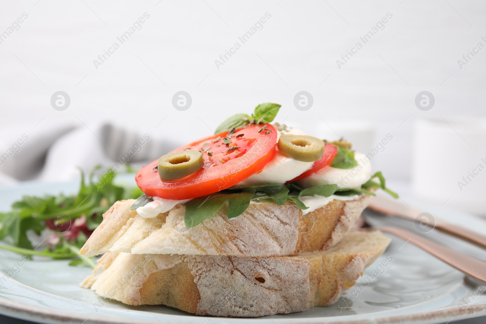 Photo of Tasty bruschetta with tomatoes, mozzarella and olives on plate, closeup