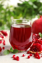 Composition with glass of fresh pomegranate juice on table