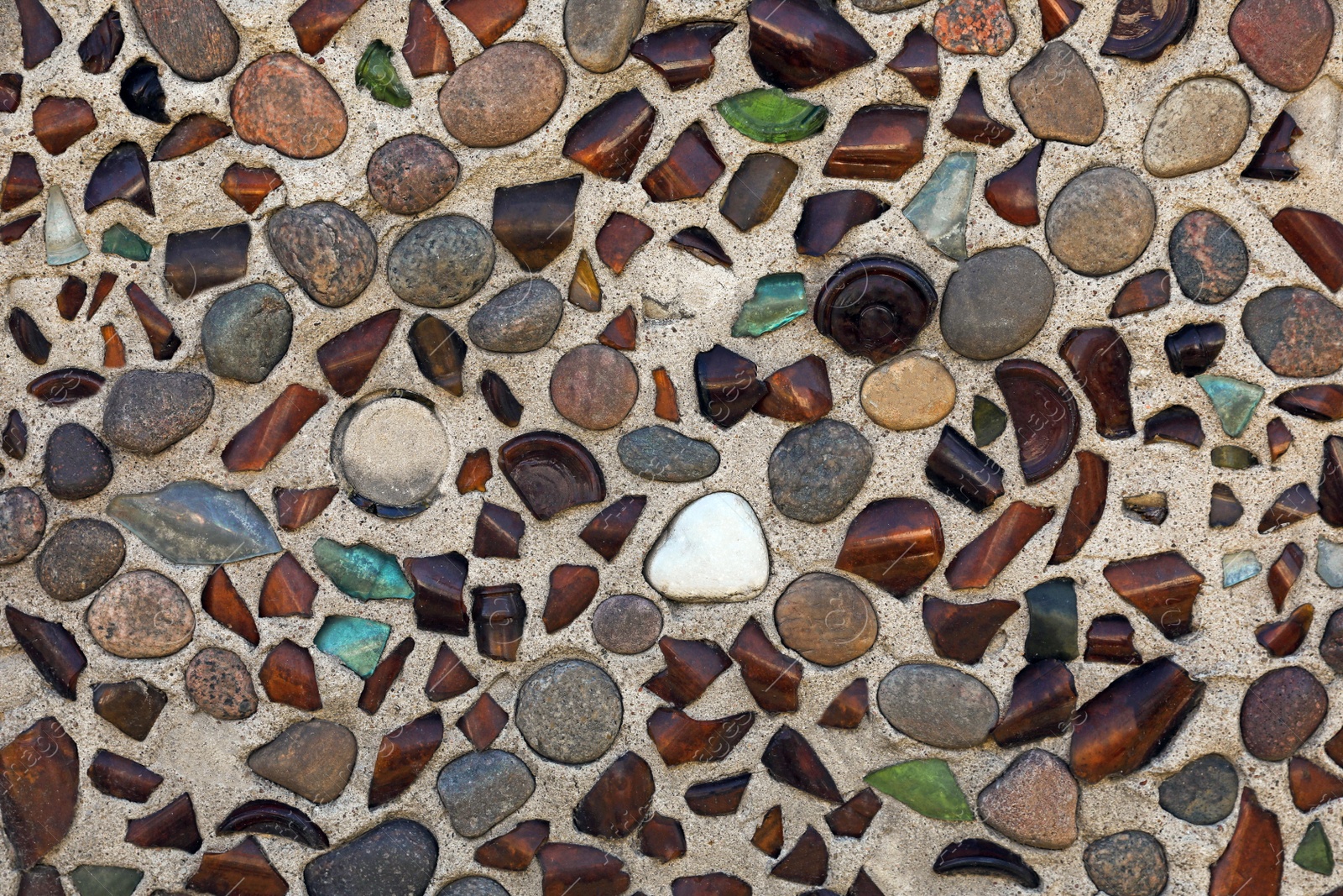 Photo of Texture of stone wall with rocks and glass pieces as background, closeup