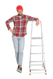 Young handsome man in hard hat near metal ladder on white background