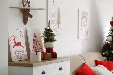 Beautiful Christmas pictures on chest of drawers indoors. Interior design