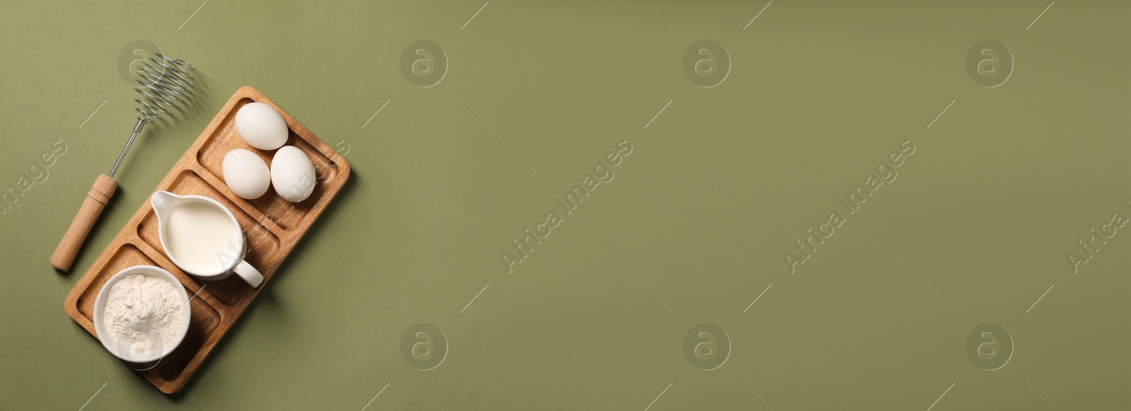 Image of Metal whisk, eggs, milk and flour on khaki background, top view. Banner design with space for text