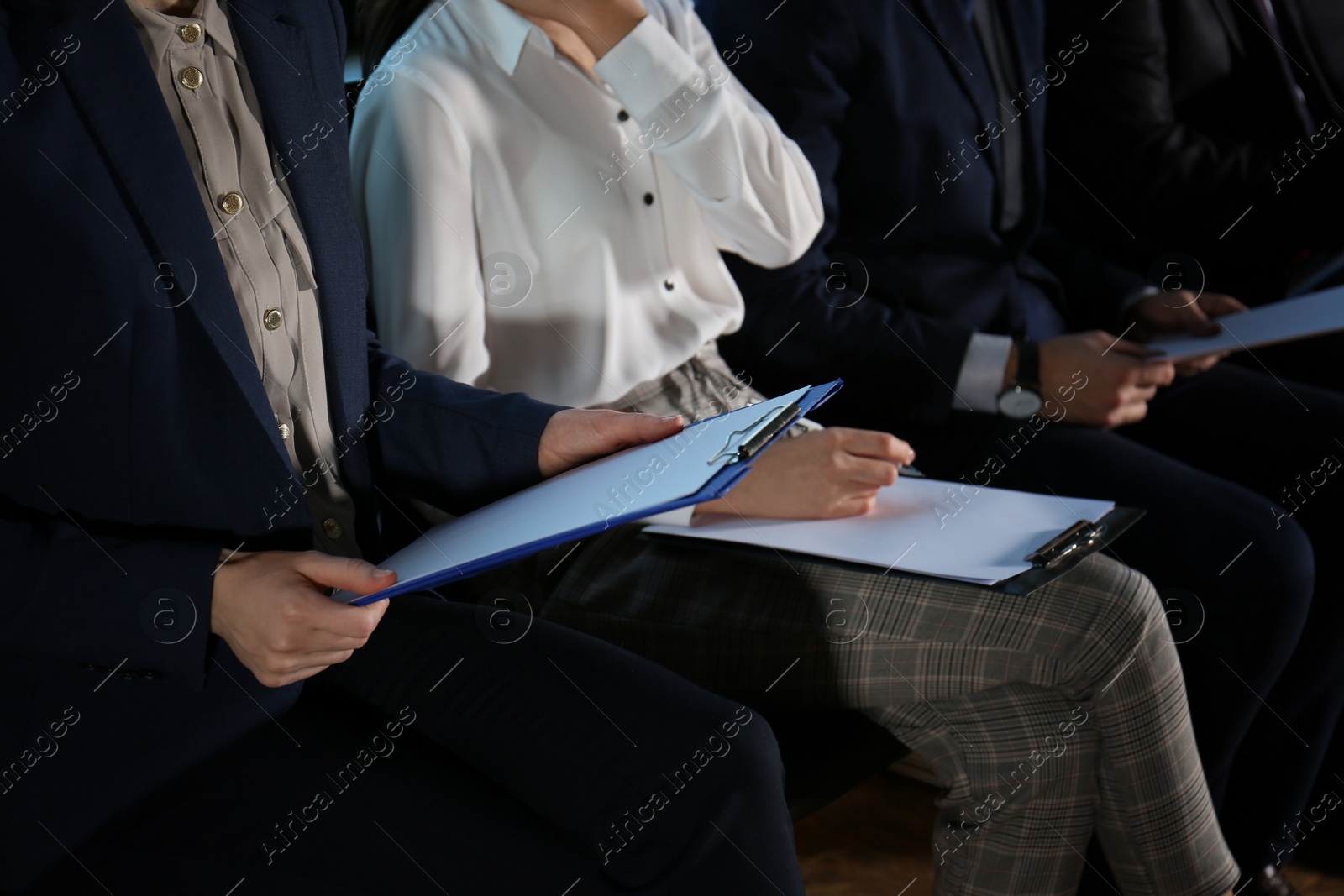 Photo of Young woman with clipboard waiting for job interview in office hall, closeup