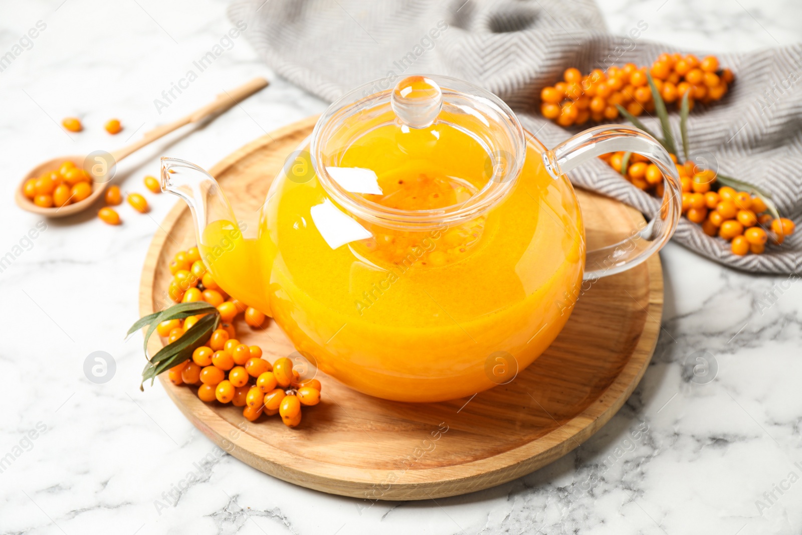 Photo of Delicious sea buckthorn tea and fresh berries on white marble table