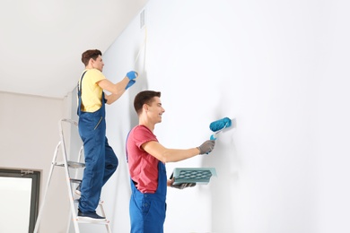 Male decorators refurbishing empty room