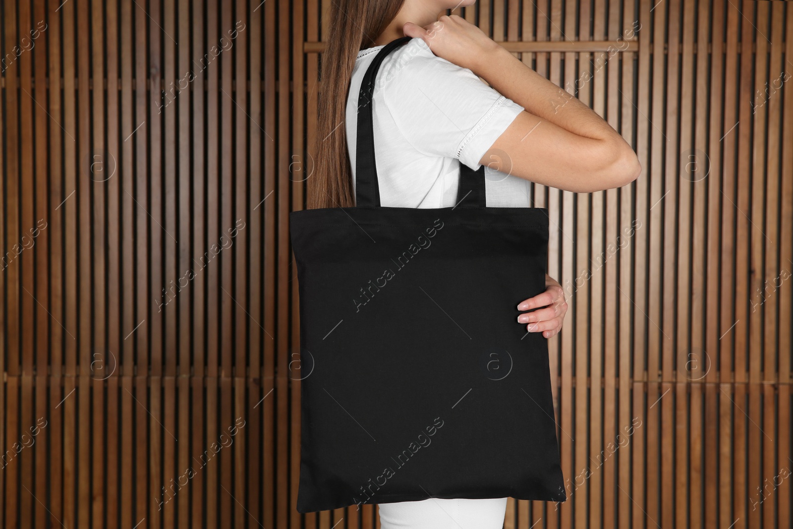 Photo of Woman with eco bag on wooden background. Mock up for design