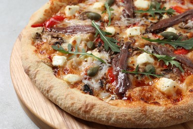 Tasty pizza with anchovies, arugula and olives on grey table, closeup