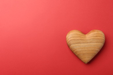 Photo of Wooden heart on red background, top view. Space for text