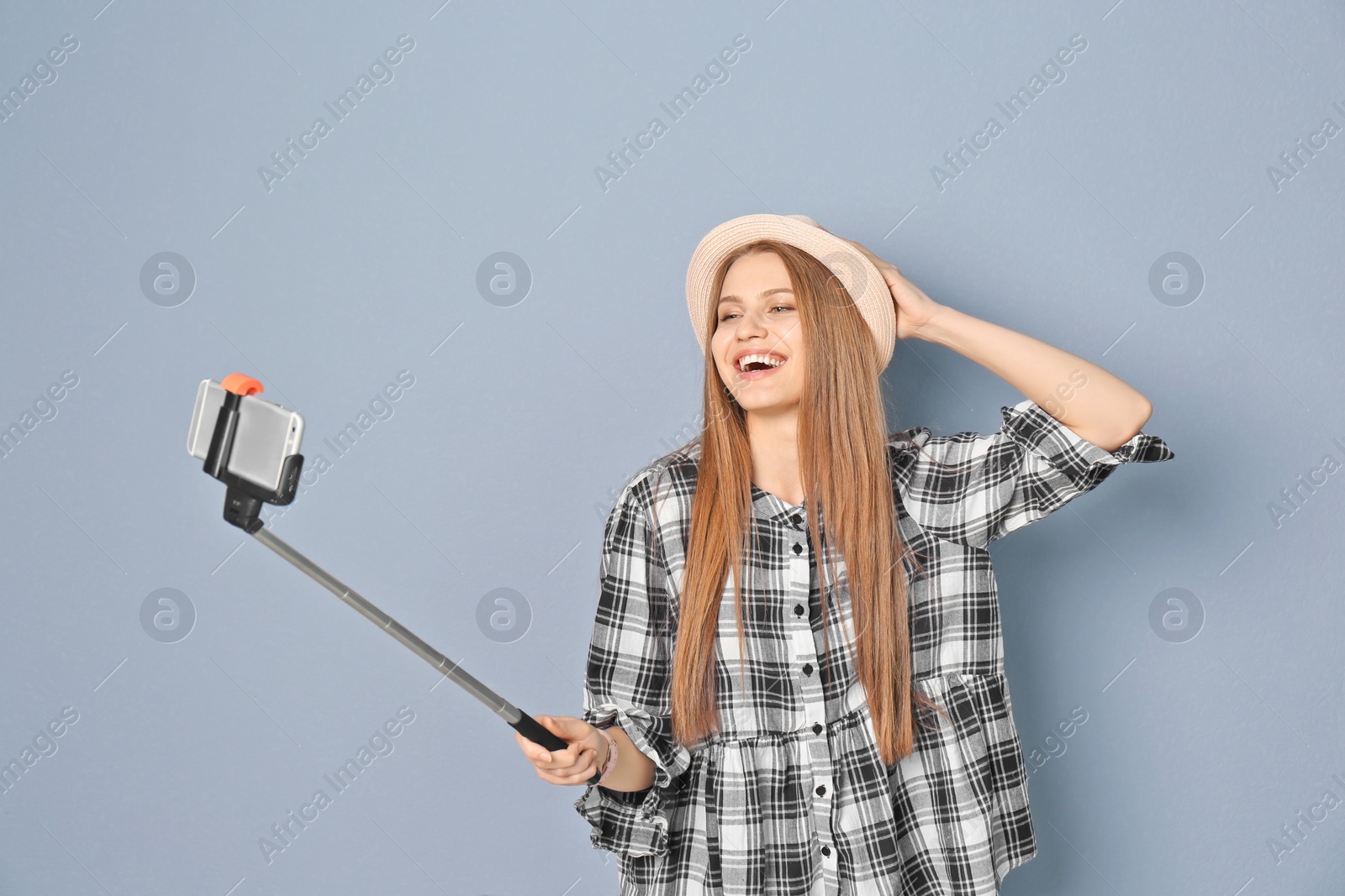 Photo of Young beautiful woman taking selfie against grey background