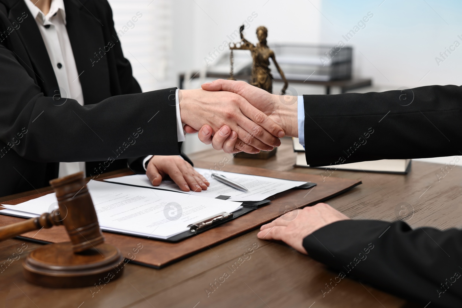 Photo of Lawyer shaking hands with client in office, closeup