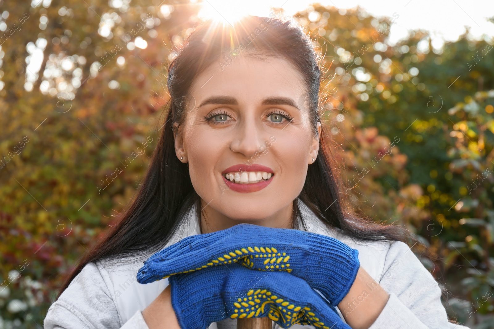 Photo of Woman wearing gloves and having rest after working in garden