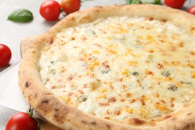 Photo of Delicious cheese pizza and tomatoes on table, closeup