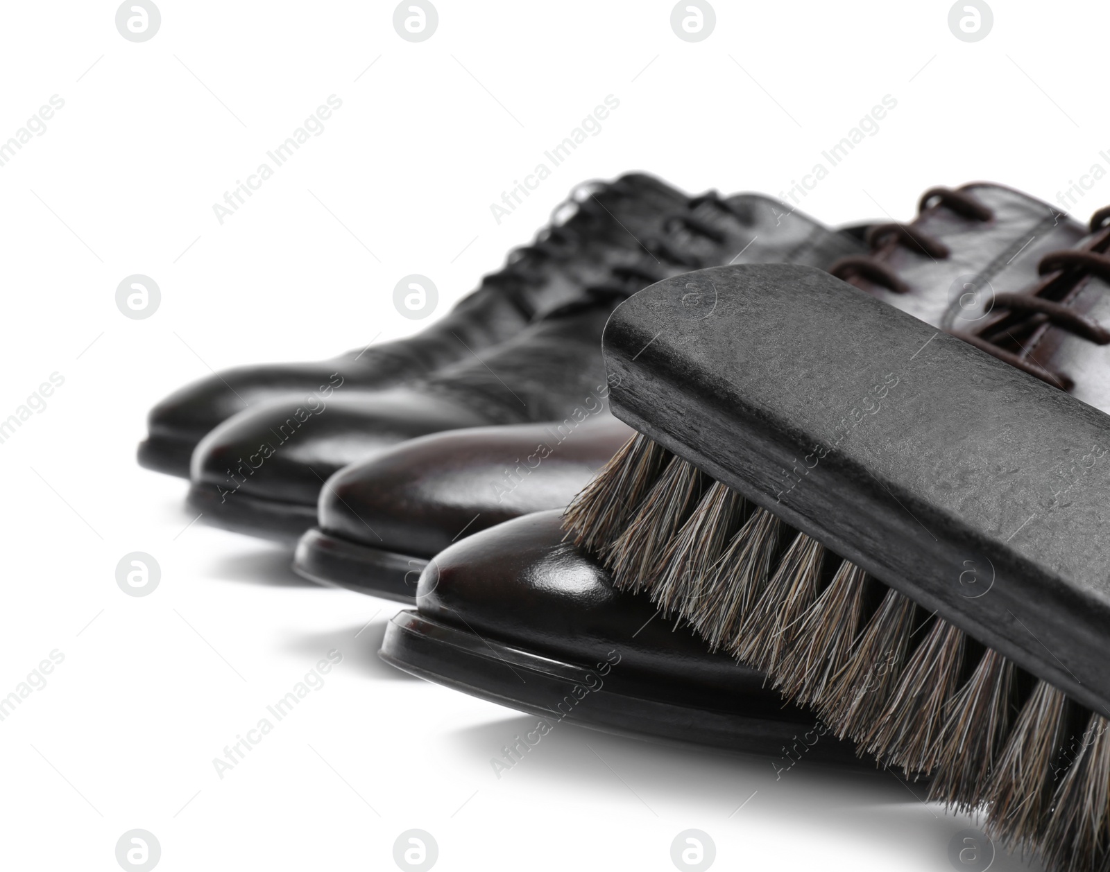 Photo of Stylish men's shoes and cleaning brush on white background, closeup