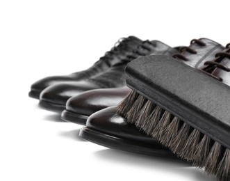 Photo of Stylish men's shoes and cleaning brush on white background, closeup