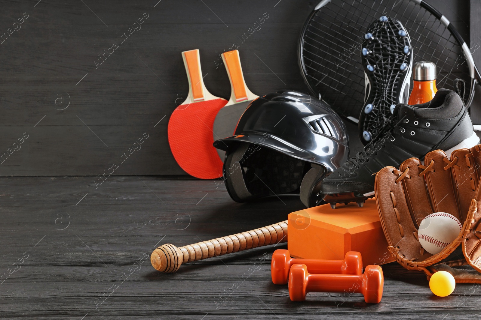 Photo of Many different sports equipment on dark grey wooden table, space for text