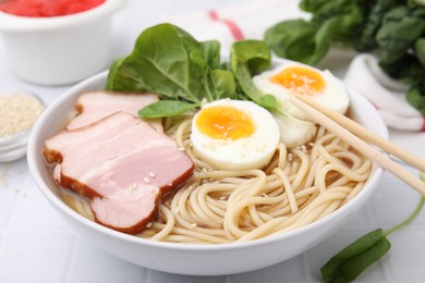 Photo of Delicious ramen with meat on white table, closeup. Noodle soup