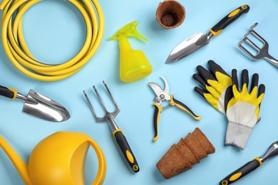 Photo of Flat lay composition with gardening tools on light blue background