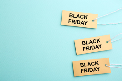 Photo of Blank yellow tags on turquoise background, flat lay with space for text. Black Friday concept