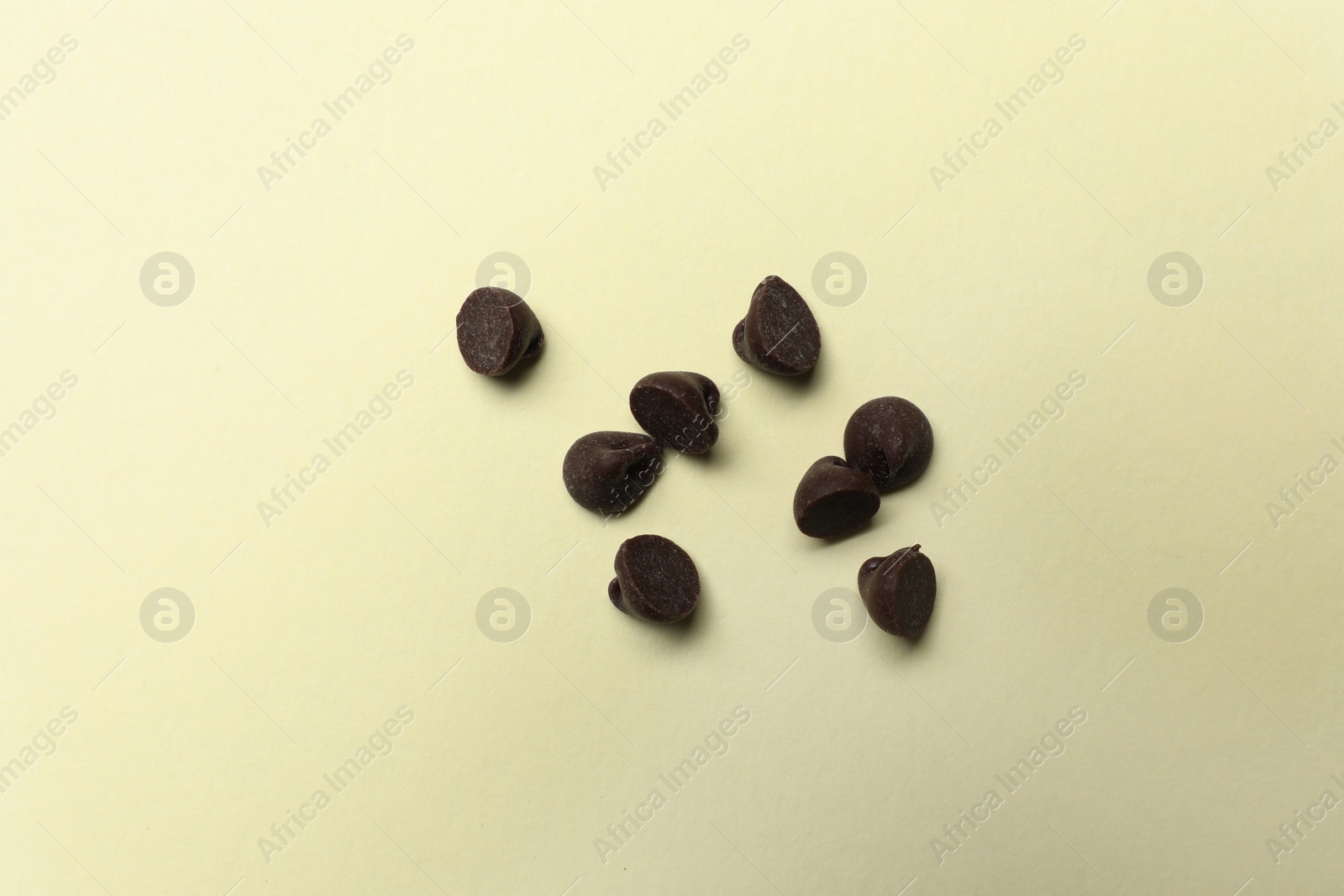 Photo of Delicious chocolate chips on beige background, top view