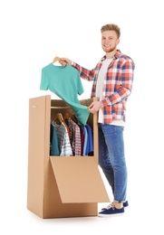Photo of Young man near wardrobe box on white background