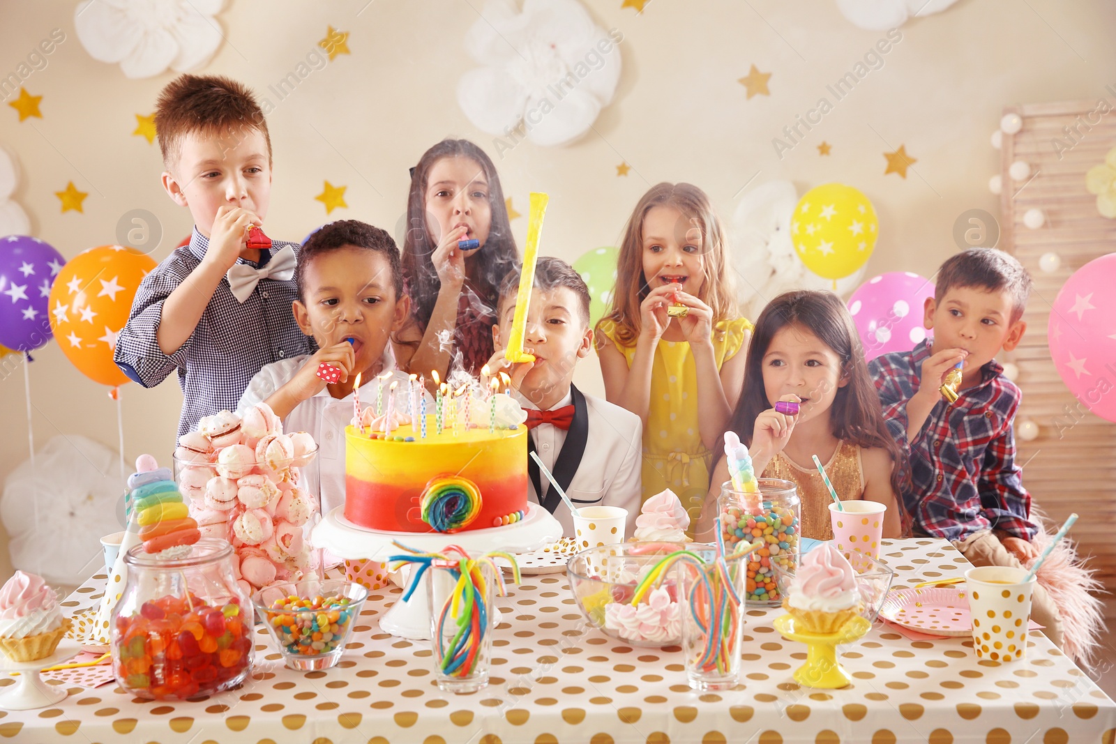 Photo of Cute children celebrating birthday at table indoors