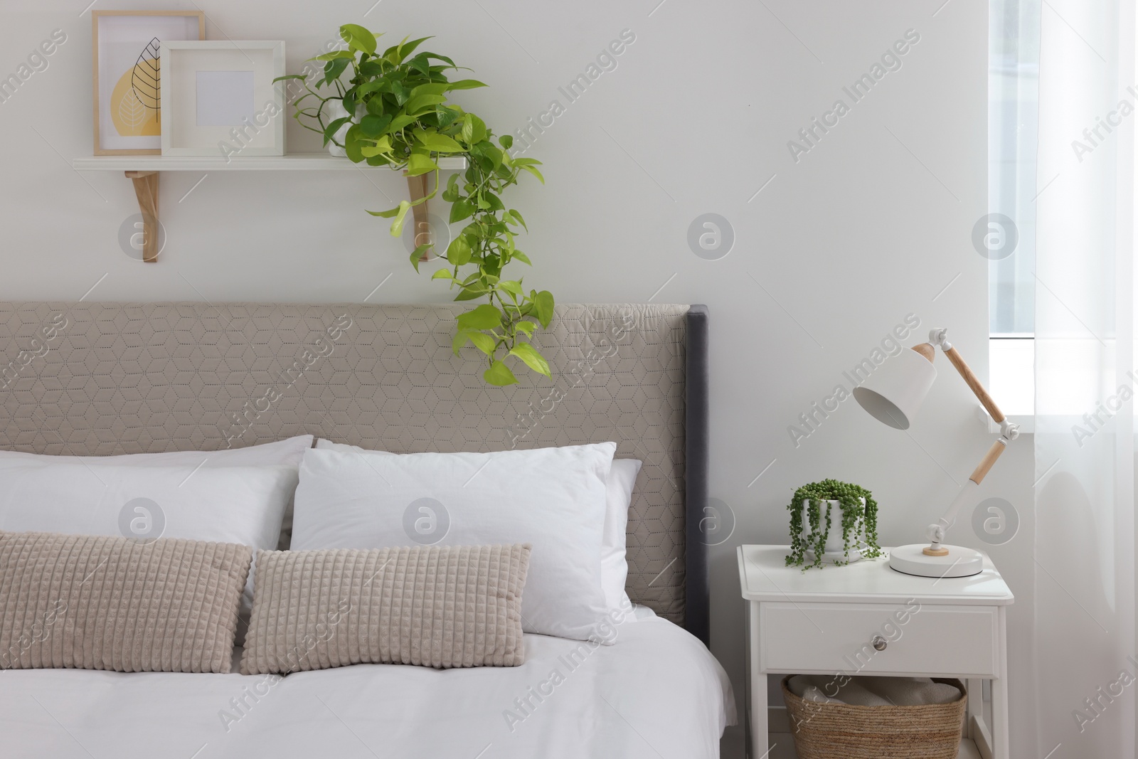 Photo of Stylish bedroom interior with large comfortable bed and bedside table