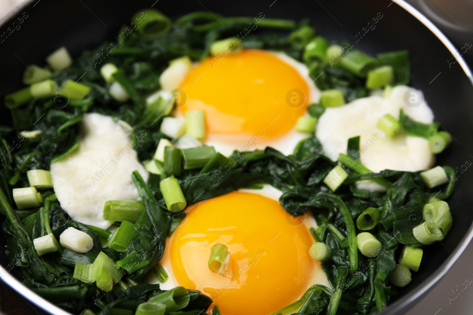 Photo of Tasty green Shakshouka in frying pan, closeup