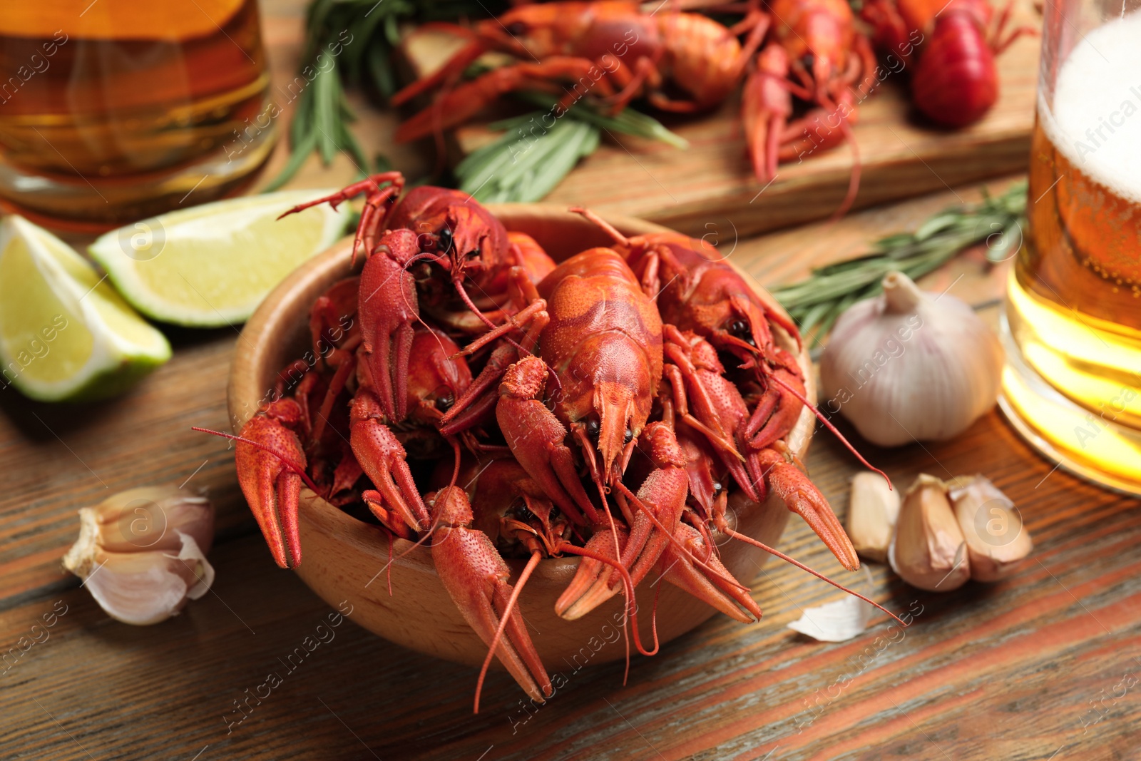 Photo of Composition with delicious red boiled crayfishes on wooden table, closeup