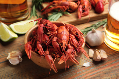 Composition with delicious red boiled crayfishes on wooden table, closeup