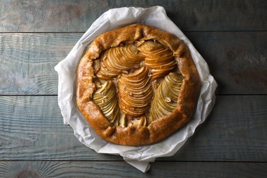 Photo of Delicious apple galette with walnuts on wooden table, top view