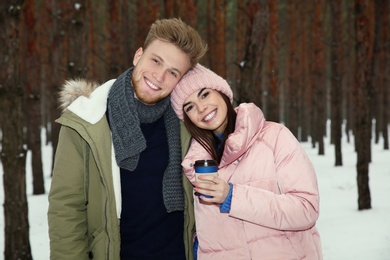 Beautiful young couple in snowy winter forest