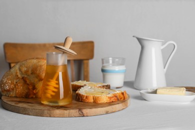 Delicious honey, milk and bread with butter served for breakfast on table