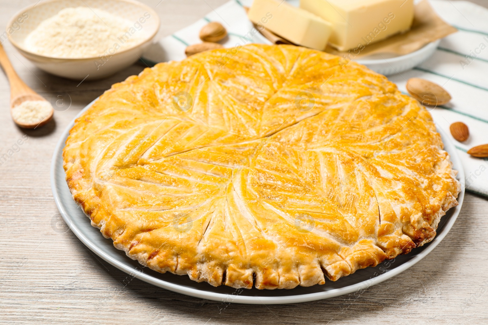 Photo of Traditional galette des rois on white wooden table, closeup