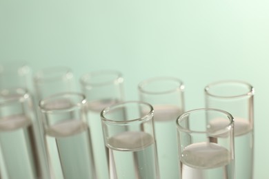 Photo of Many glass test tubes on light background, closeup