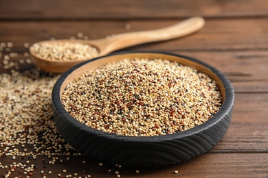 Photo of Plate with mixed quinoa seeds on wooden table