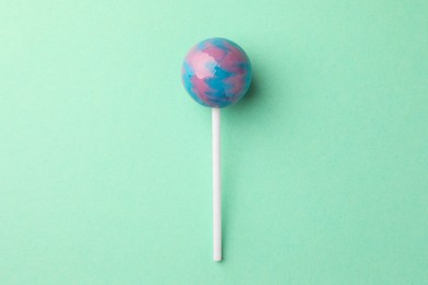 Photo of Tasty lollipop on turquoise background, top view