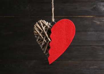 Decorative heart with red felt half against wooden background