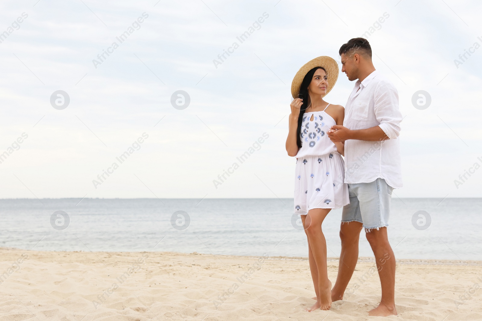 Photo of Lovely couple spending time together on beach. Space for text